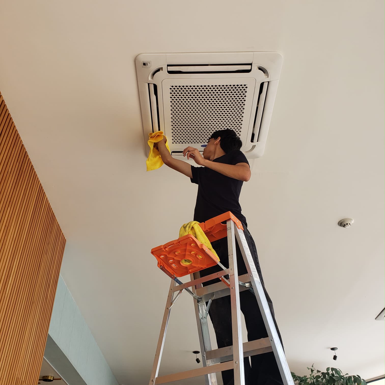Técnico de INTEC dando mantenimiento a una unidad de aire acondicionado tipo cassette