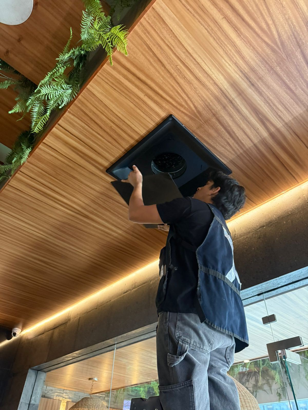 Técnico de INTEC realizando mantenimiento a un extractor de aire